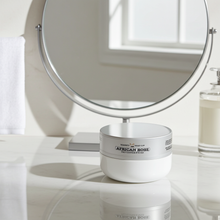 Load image into Gallery viewer, White container labeled 'African Rose' on a bathroom counter with a mirror in the background.