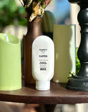 Load image into Gallery viewer, Dapper Hand Lotion displayed beside green candles, a brown vase, and black décor.
