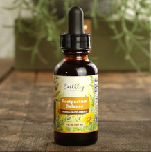 Load image into Gallery viewer, Bottle of Earthly Postpartum Balance herbal supplement on a wooden surface with plants in the background