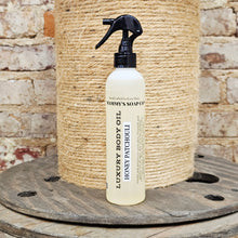 Load image into Gallery viewer, Bottle of Mammy's Soap Co Honey Patchouli luxury body oil with a spray nozzle on a rustic wooden surface.