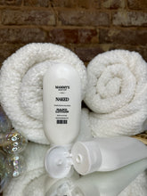 Load image into Gallery viewer, Two white squeeze bottles of hand lotion on a textured surface