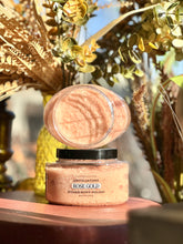 Load image into Gallery viewer, Rose Gold Sugar Body Polish displayed open on a red wooden table surrounded by plants and fall décor.