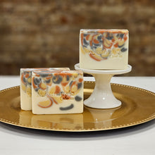 Load image into Gallery viewer, Two bars of handcrafted soap on a white plate with a decorative edge, with the brand 'Mammy's Soap Co.' visible on the soap.