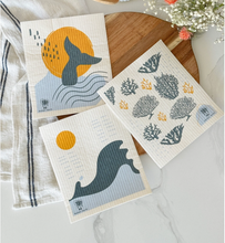 Load image into Gallery viewer, Set of three decorative towels with whale and coral designs on a wooden surface.