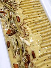 Load image into Gallery viewer, loaf of yellow green freshly made handcrafted bar soap topped with cinnamon stick lemongrass olive leaf and anise seed
