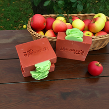 Load image into Gallery viewer, three bars of red and green soap on a wood table next to a basket of apples
