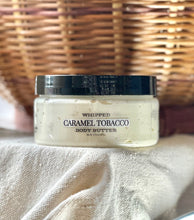 Load image into Gallery viewer, Caramel Tobacco whipped body butter displayed with warm fall décor.

