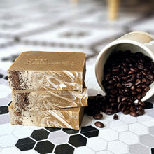 Load image into Gallery viewer, Stack of three beige bars of soap on a black and white tile surface with a spilled cup of coffee beans alongside.
