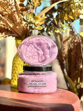 Load image into Gallery viewer, Dreamcatcher Sugar Body Polish displayed open on a red wooden table surrounded by plants and fall décor.
