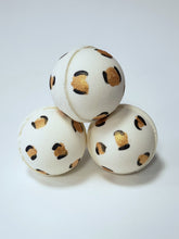 Load image into Gallery viewer, Three white bath bombs with gold and black leopard print pattern on a light gray background

