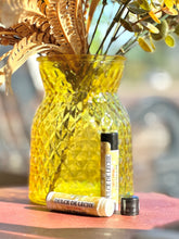 Load image into Gallery viewer, Dulce de Leche lip balm displayed with golden fall décor.

