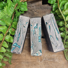 Load image into Gallery viewer, Three rectangular soap bars with marbled design on a wooden surface with green foliage.
