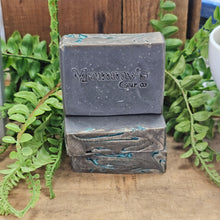 Load image into Gallery viewer, Three bars of soap from 'Mammy's Soap Co' on a wooden surface with green leaves in the background.
