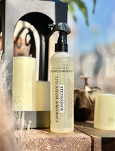 Load image into Gallery viewer, Honeysuckle Luxury Body Oil displayed on a wooden table beside a black lantern, candle, and fall pumpkin.
