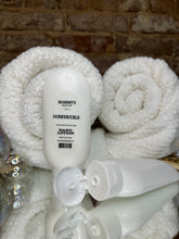 Load image into Gallery viewer, Two white squeeze bottles of hand lotion on a textured surface
