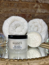 Load image into Gallery viewer, Bottle of Mammy's Island Coconut body cream with rolled towels on a textured surface
