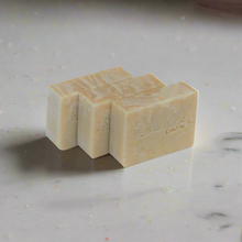 Load image into Gallery viewer, Three bars of soap stacked on a marble surface with 'Mammy's branding.
