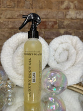 Load image into Gallery viewer, Relax Luxary Body Oil bottle with a spray nozzle on a textured surface with bubbles.
