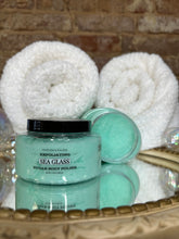 Load image into Gallery viewer, Sea green body polish jars with white towels on a textured surface
