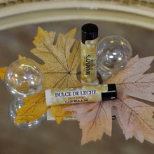 Load image into Gallery viewer, 2 lip balm tubes of dulce de leche with fall background
