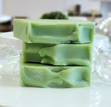 Load image into Gallery viewer, Stack of green bar soaps on a white surface with blurred objects in the background.
