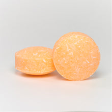 Load image into Gallery viewer, two round yellow orange shampoo pucks
