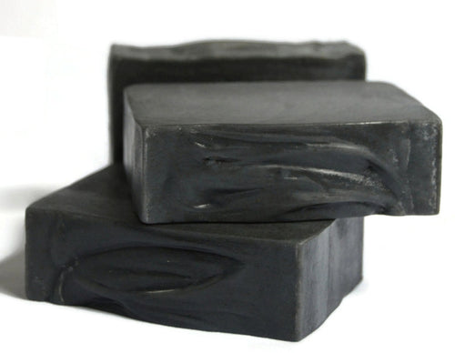 2 jet black soap bars stacked with another in the back on a white background
