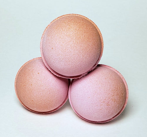Three stacked pink and gold bath bombs